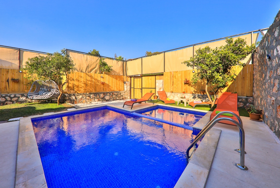 Özel havuzlu bahçe, şezlonglar ve salıncak.